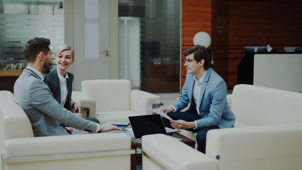 Three professionals in a modern office lounge.
